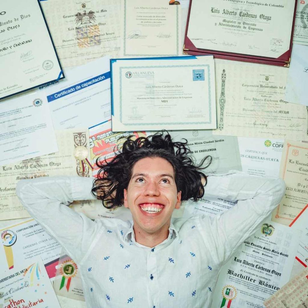 a man lying on a bunch of diplomas