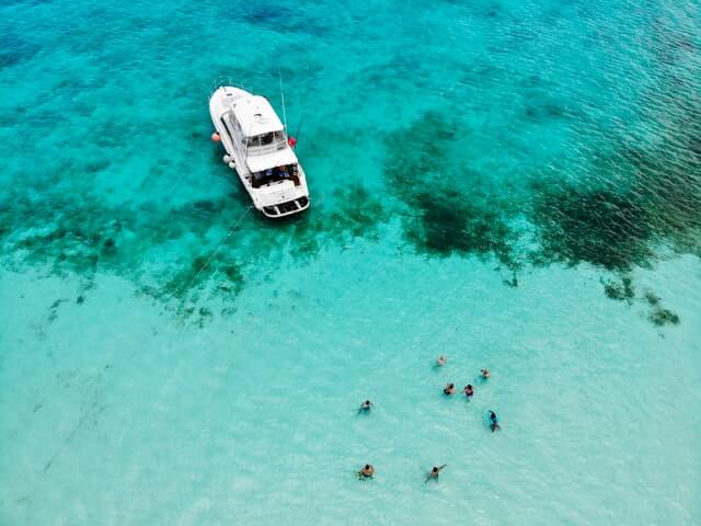 People swimming in the ocean in Cozumel next to a boat