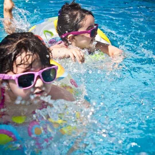 two babies swimming in a pool